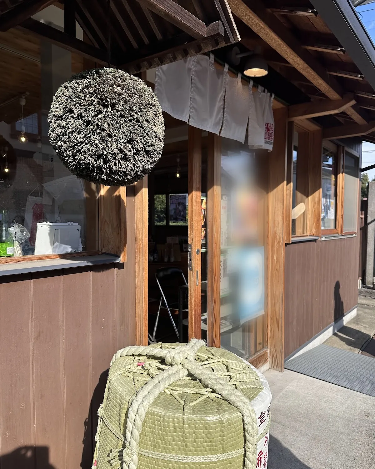 晴れた日の豊島屋酒造の店先・軒先の杉玉と菰樽