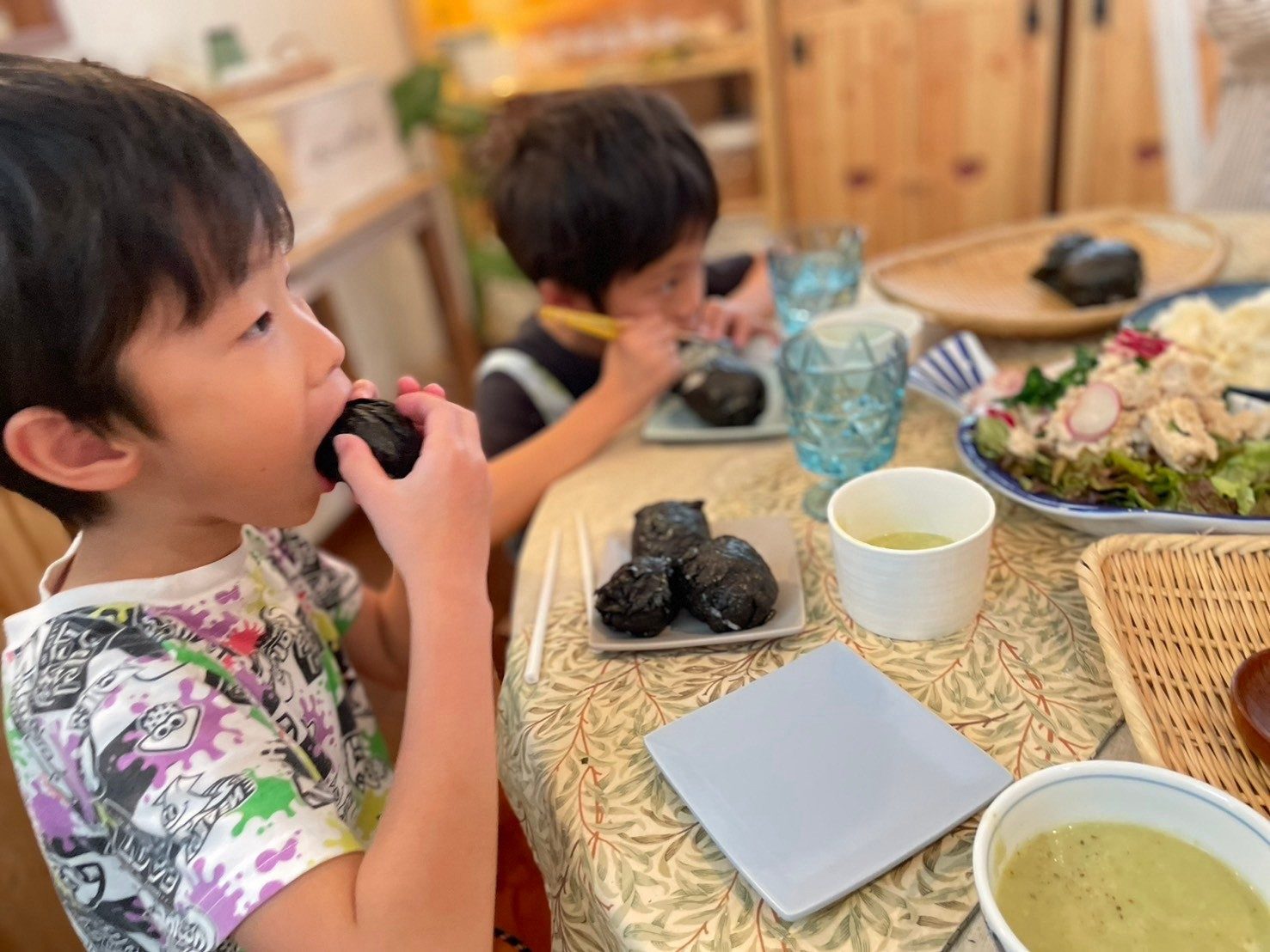 食卓で子どもが料理を味見している様子